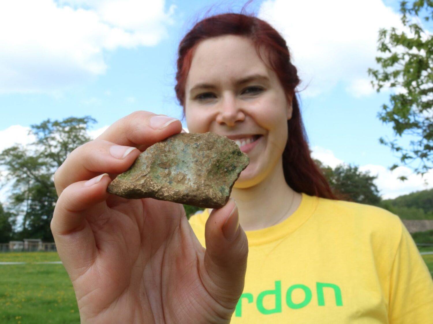 Archaeologist with fragment of hand-made green glazed pottery