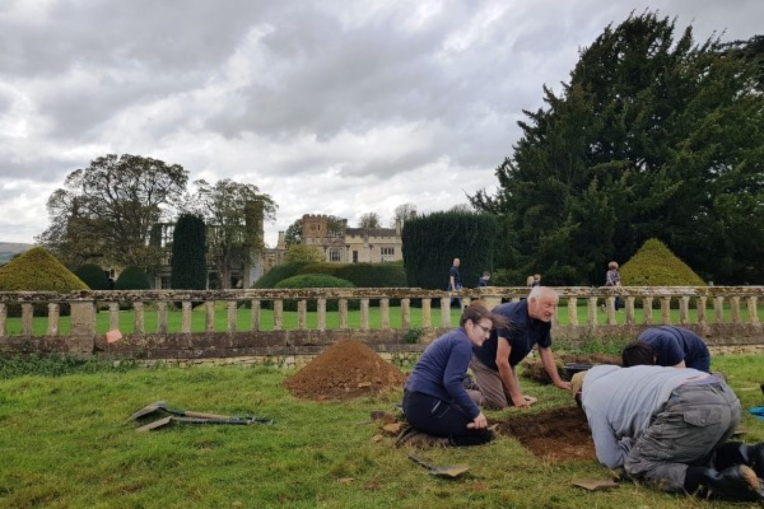 Archaeologists digging a trench in the Sudeley gardens