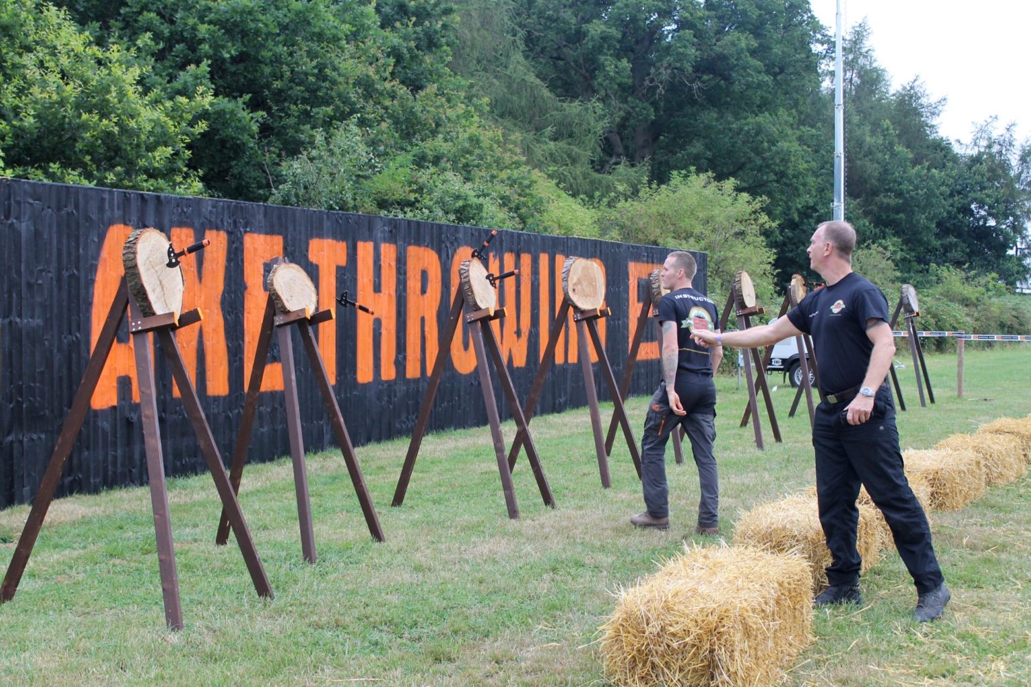 Men throw hand axes at targets