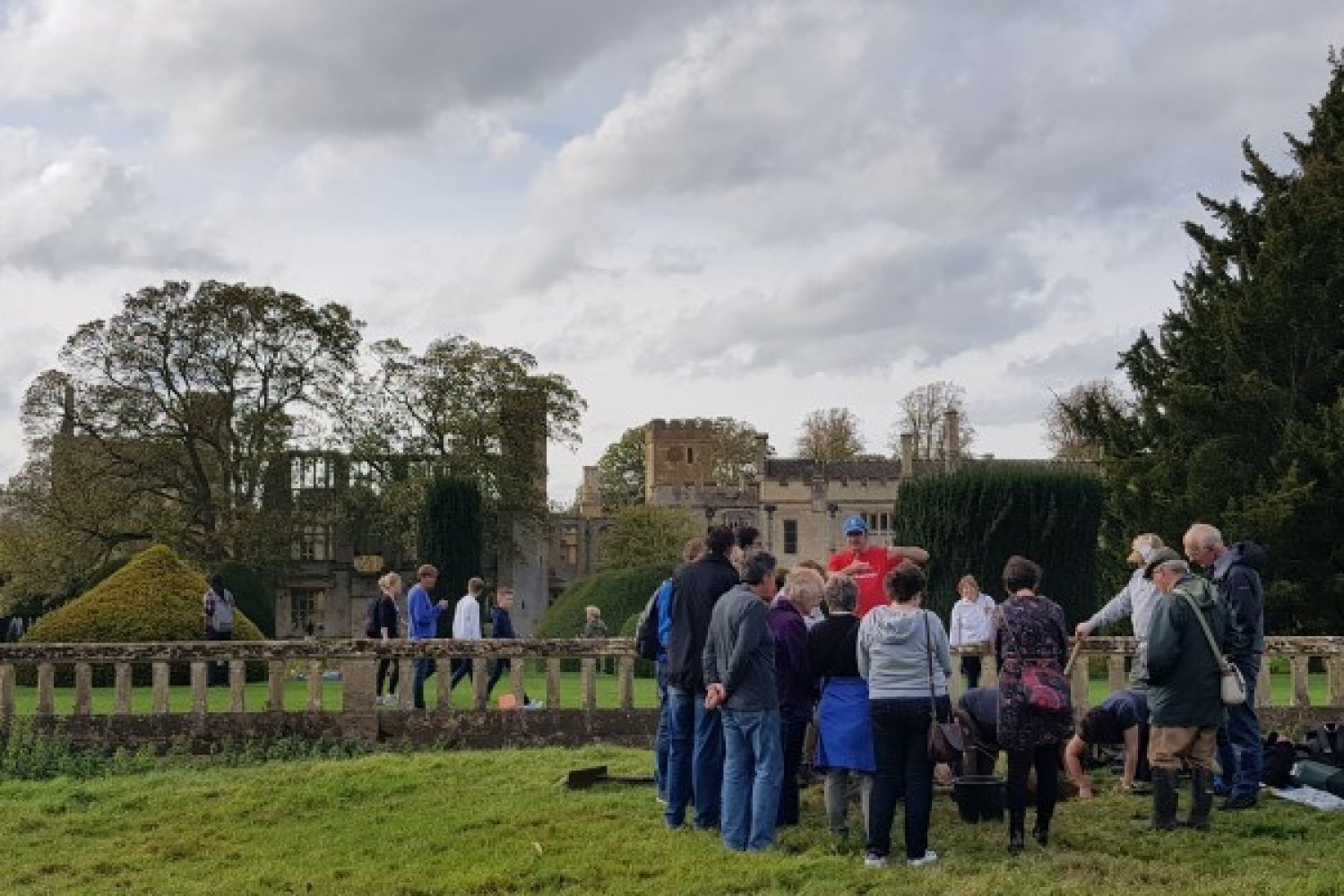 A group of visitors surround one of the dig sites