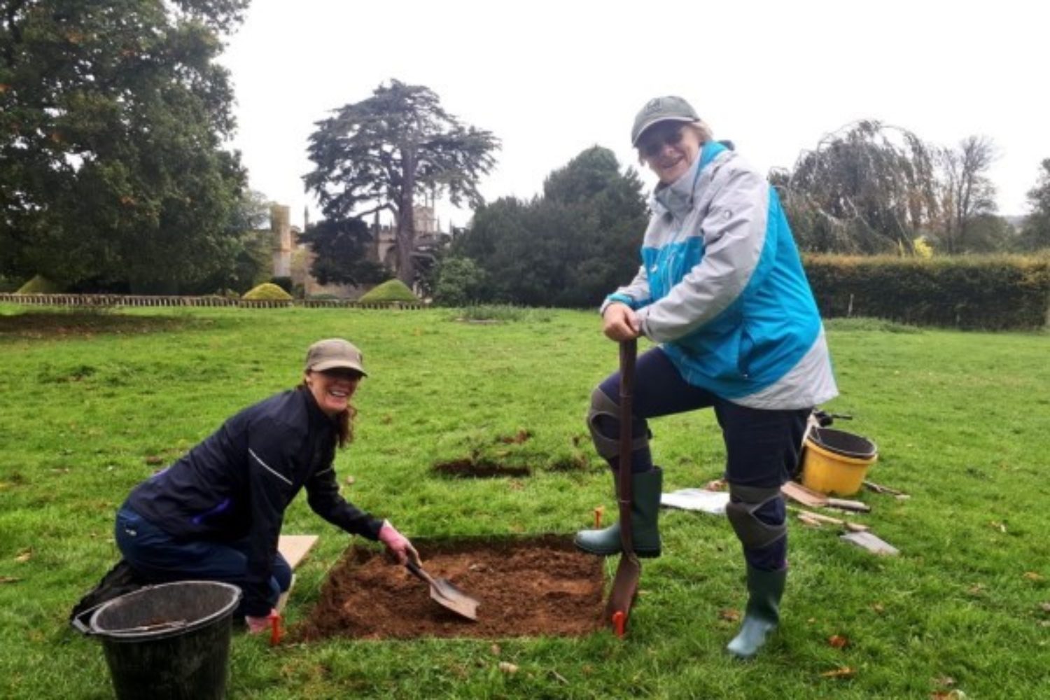 Diggers armed with spades stand around dig site