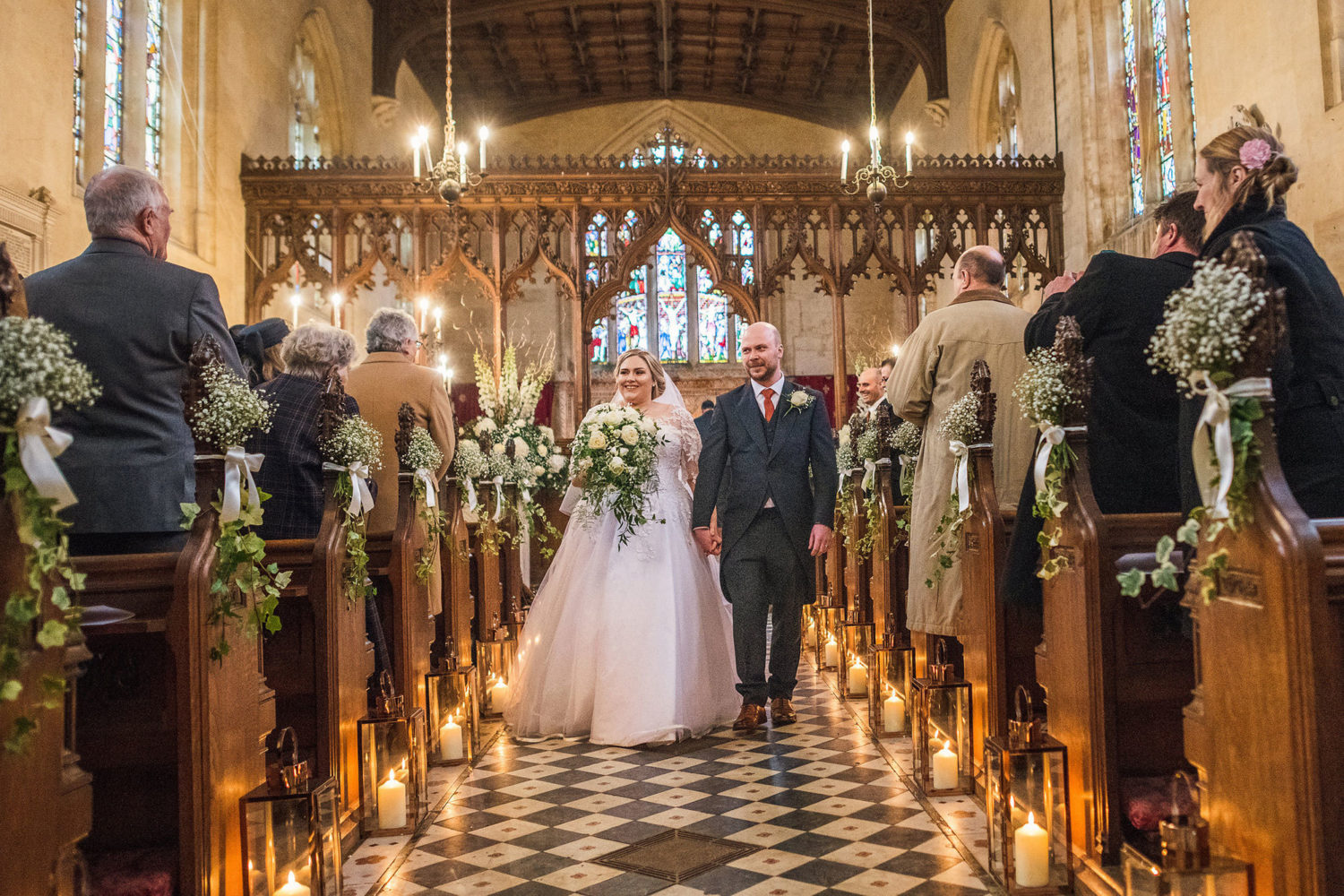 Newly married couple walk down chapel aisle